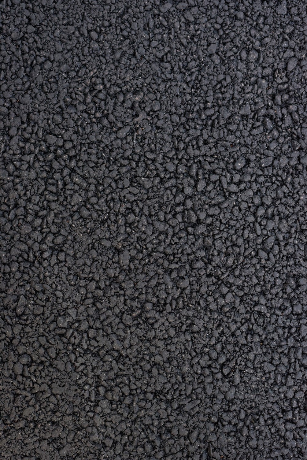 Texture of the black asphalt. Road surface. Close up. Vertical frame